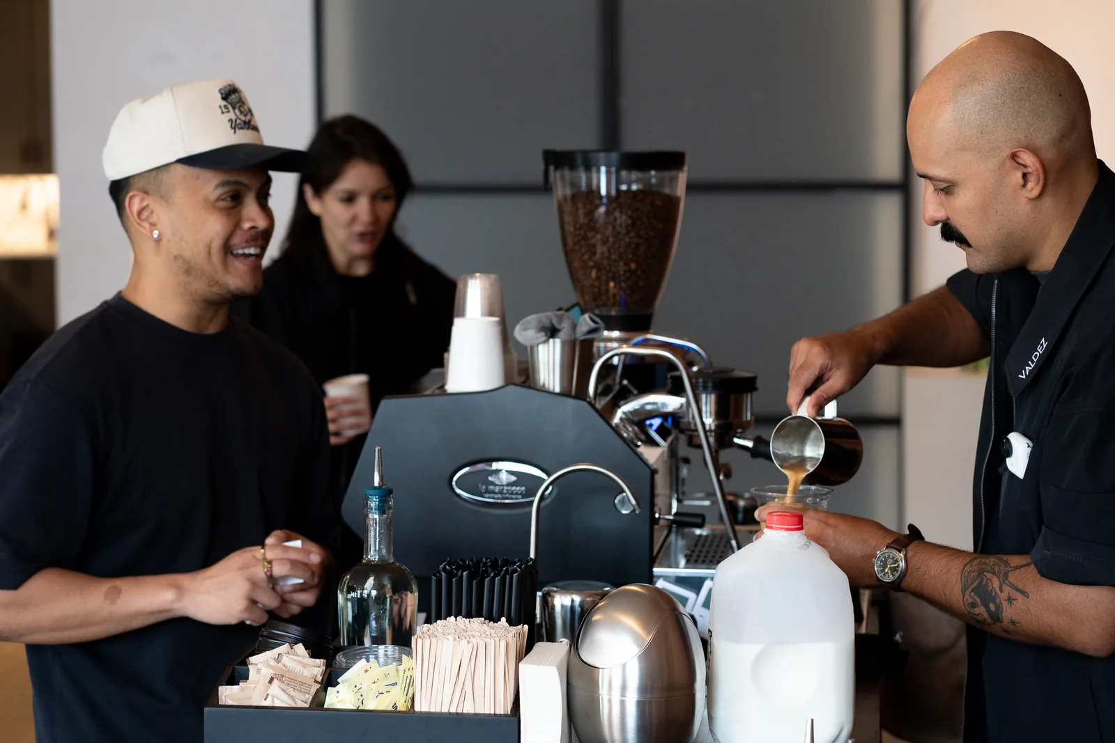 Michael Valdez pours espresso at the ValdezNY coffee cart while a guest smiles across the bar