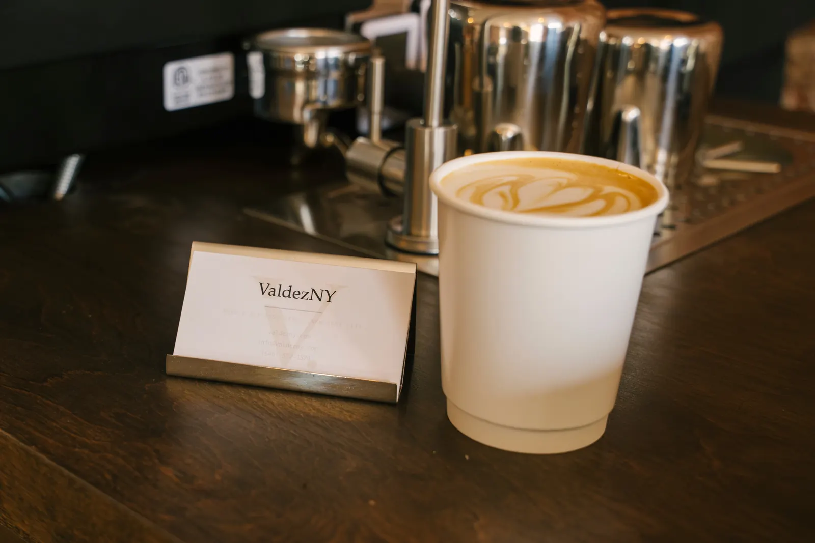 A rosetta poured in a ValdezNY cup beside the ValdezNY card