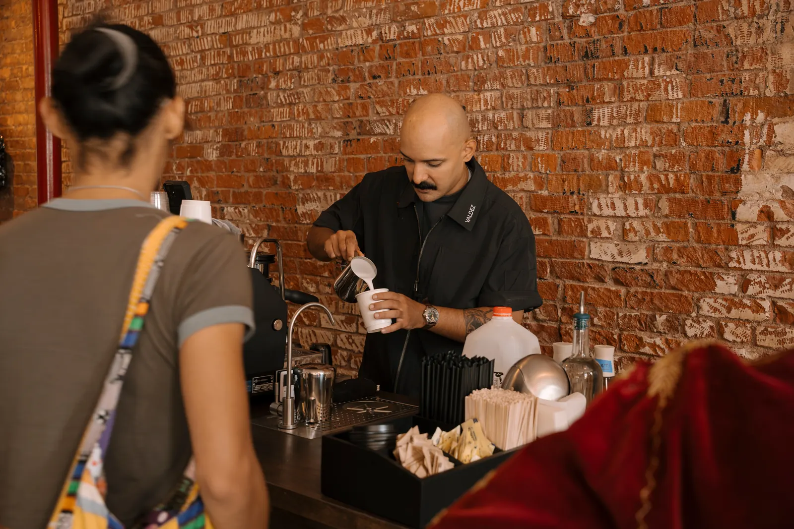 Michael Valdez, founder of ValdezNY, pouring a drink for a guest at the espresso bar